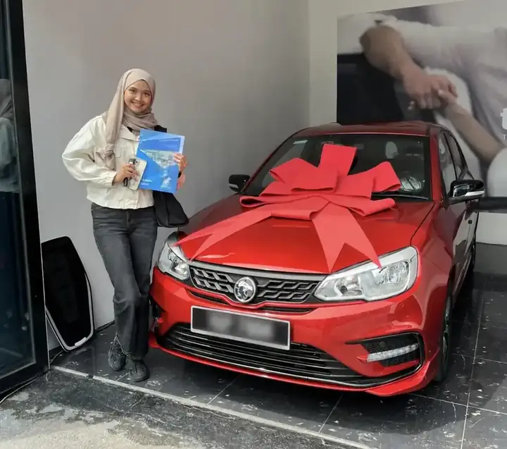 Pelanggan menerima PROTON merah dengan reben penyerahan