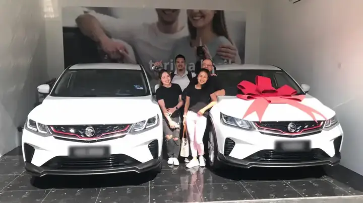 Keluarga bergambar bersama dua buah PROTON putih